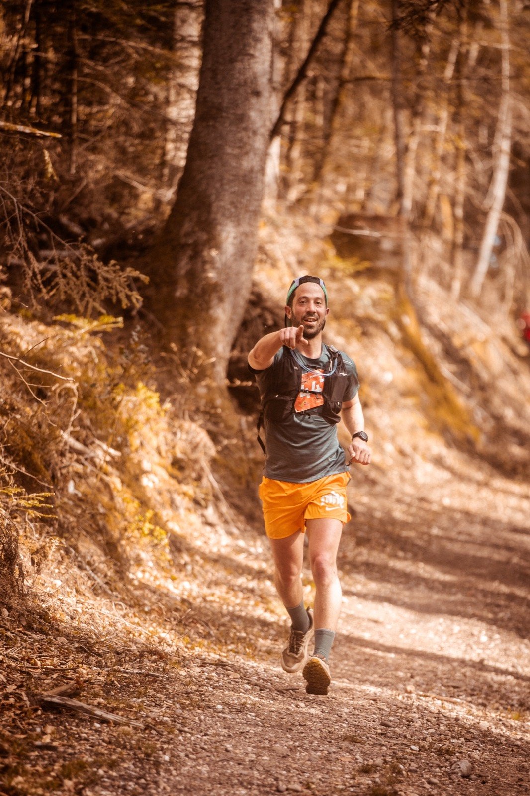 Coureur souriant sur un chemin forestier ensoleillé